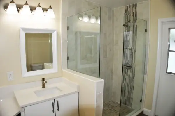 Renovated bathroom with frameless glass shower and marble tile