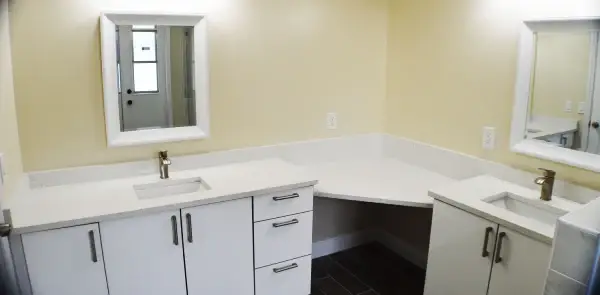 Renovated bathroom with double vanity and tiled shower