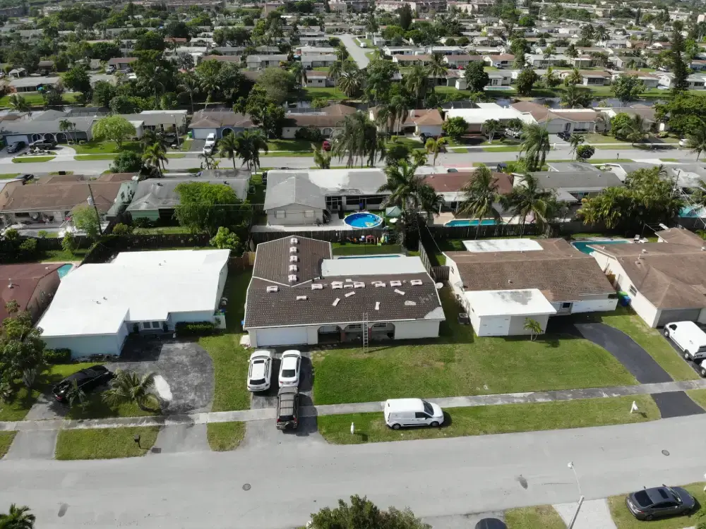 Completed white flat roof and shingle roof system seen from above