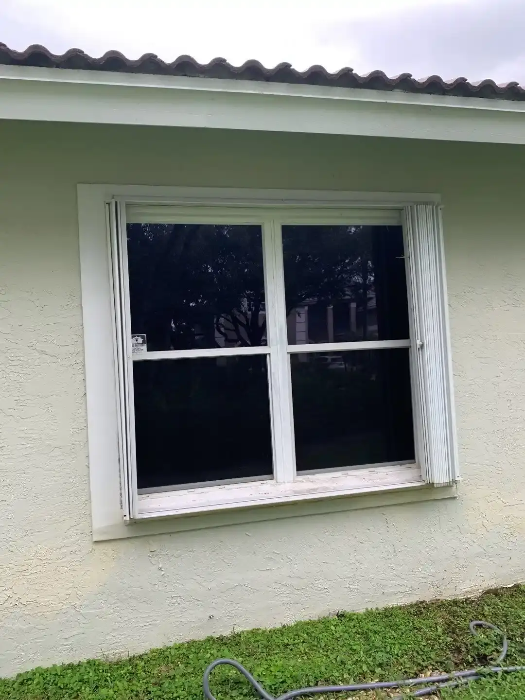 Accordion shutters closed across a sliding glass door on a patio