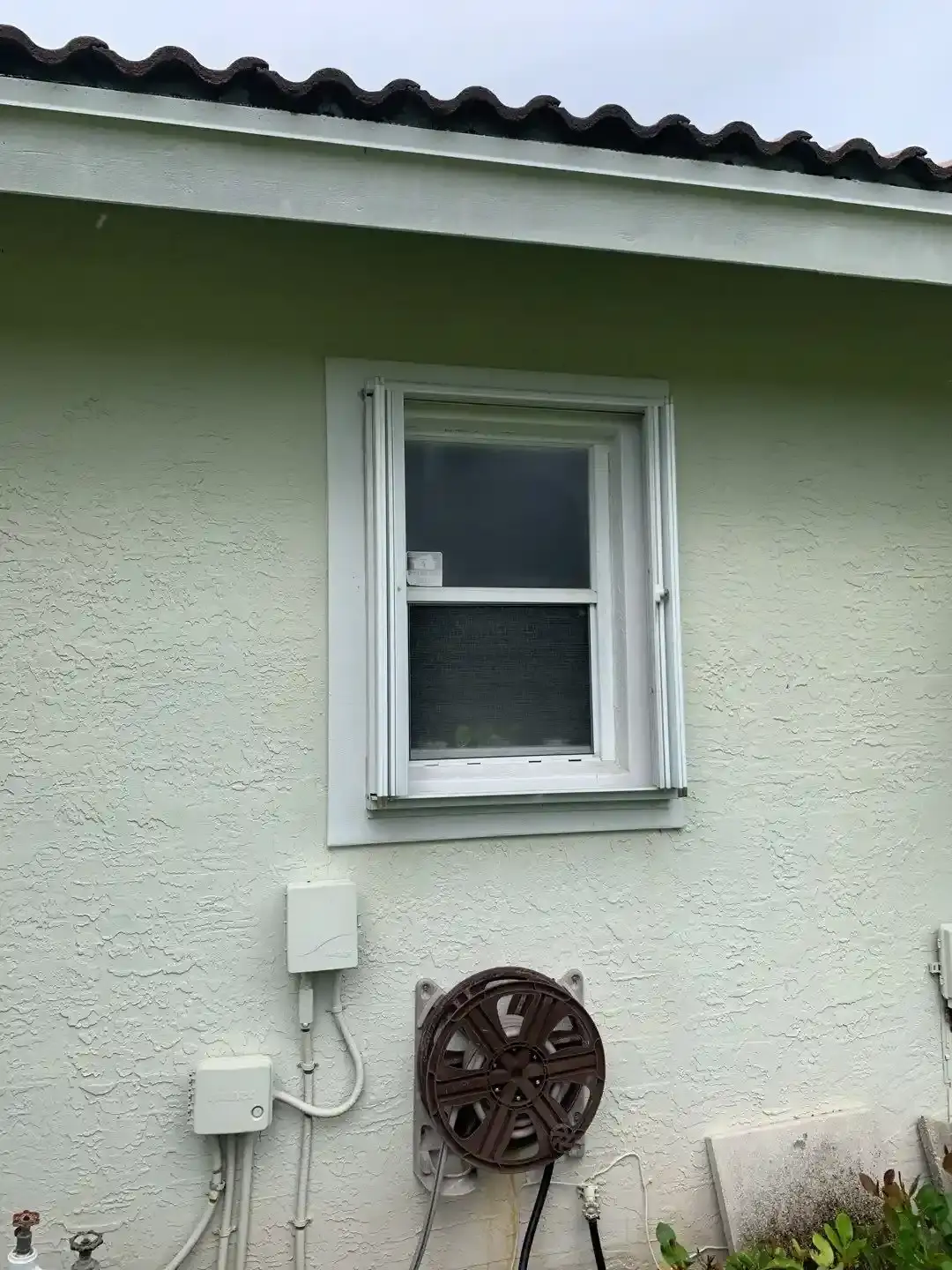 Accordion hurricane shutter partially deployed on a South Florida home