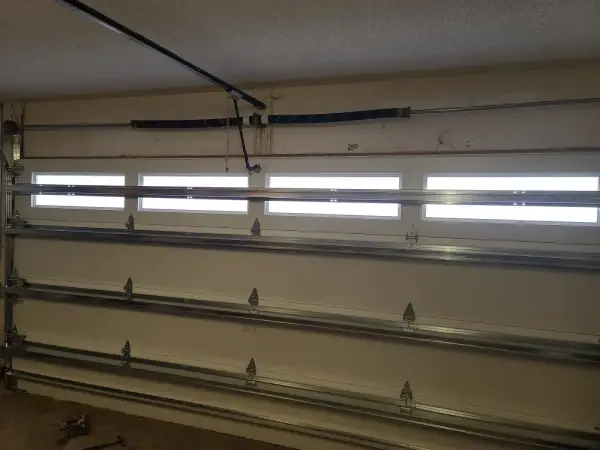 Interior view of a new insulated garage door with window inserts and track