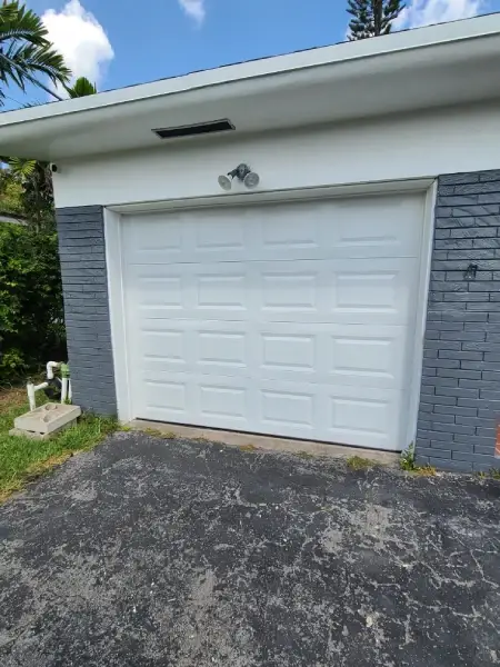 New white garage door installed on a single-car garage