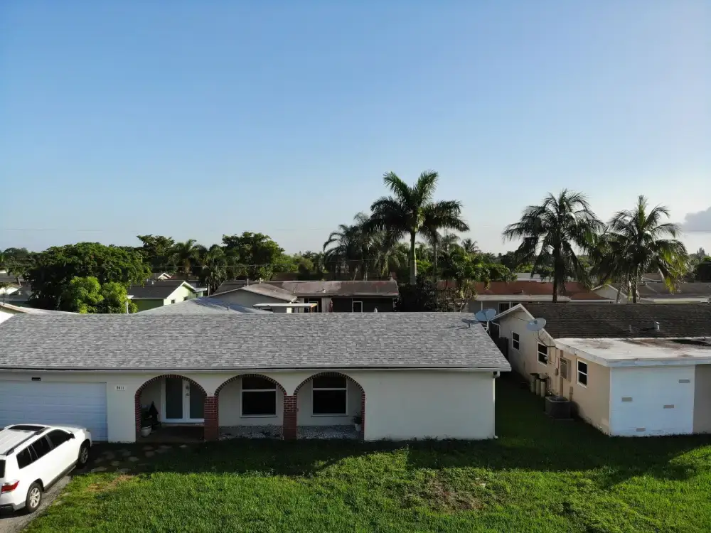 Aerial view of a dense Hialeah, Florida neighborhood with roofing work in progress