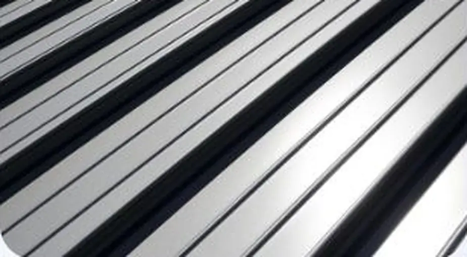 Close-up of silver standing seam metal roof panels showing the raised interlocking ribs